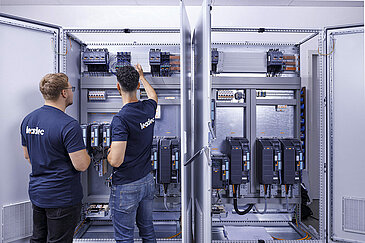 Two Leadec employees checking a switch cabinet.